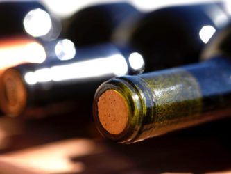 Find a sturdy object smaller than the opening of the bottle and slowly push the cork down. Westend61/Getty Images