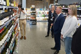 Trade and Investment Minister Todd McClay examines New Zealand wines on sale in a London supermarket. Photo: Supplied